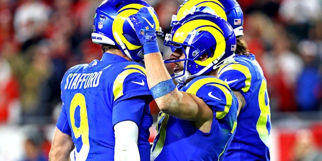 Los Angeles Rams quarterback Matthew Stafford (9) celebrates with wide receiver Cooper Cup (10) after playing during the second half against the Tampa Bay Buccaneers in an NFL playoff game at Raymond James Stadium.