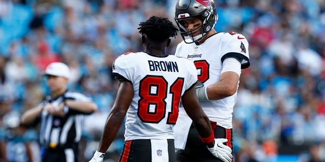 Tom Brady #12 of the Tampa Bay Buccaneers interacts with Antonio Brown #81 during the second half of a game against the Carolina Panthers at Bank of America Stadium on December 26, 2021 in Charlotte, North Carolina. 