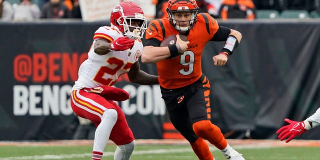 Cincinnati Bengals quarterback, Joe Burrow (9) defends against the Kansas City Chiefs, Rashad Fenton (27) during the first half of an NFL football game, Sunday, Jan. 2, 2022, in Cincinnati.