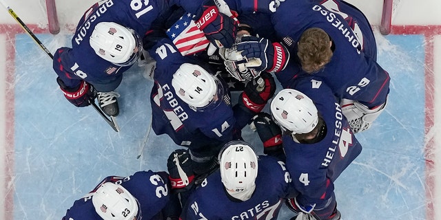 United States players console goalkeeper Strauss-Mann after losing to Slovakia 3-2 in a penalty shootout in the men's hockey quarterfinal match at the 2022 Winter Olympics on February 16, 2022, in Beijing. 