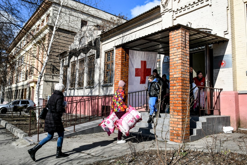 Volunteers carrying supplies enter a Red Cross site in Ukraine