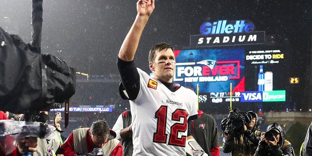 Tom Brady #12 of the Tampa Bay Buccaneers waves to the crowd as he runs off the field after defeating the New England Patriots in the game at Gillette Stadium on October 3, 2021 in Foxboro, Massachusetts.